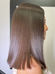 Side profile of a person with straight, shoulder-length brown hair with a blunt cut?